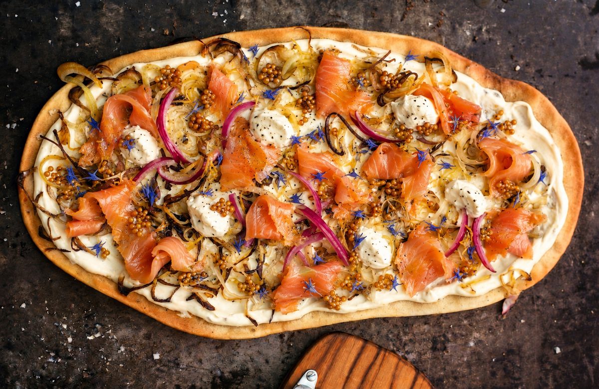 Flammkuchen mit Rauchlachs, roten Zwiebeln und Senfkörnern