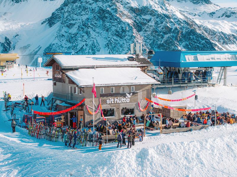 Die sit hütte von oben mit voller Terrasse, Girlanden und dem Aroser Bergpanorama