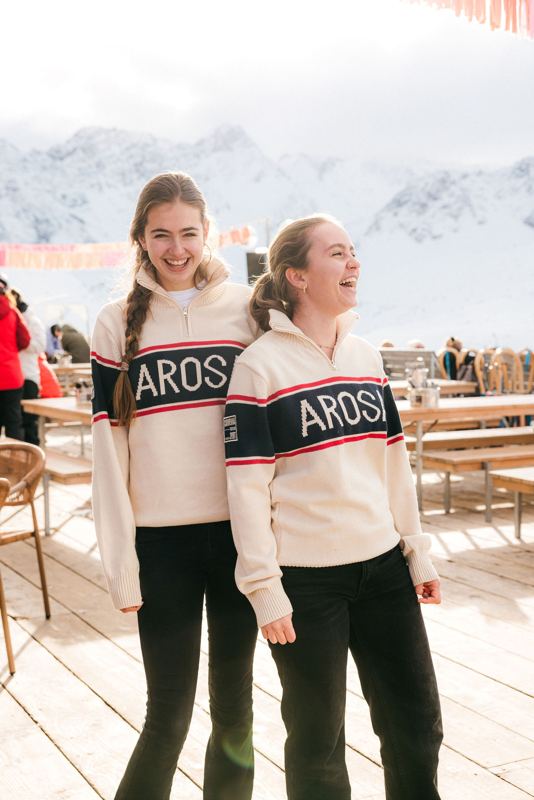 Zwei Freundinnen in Arosa-Pullovern auf der Terrasse
